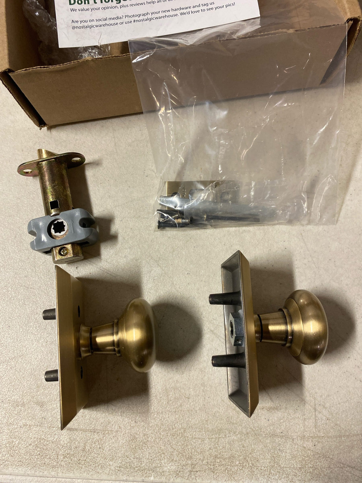Nostalgic Warehouse 713235 New York Solid Brass Passage Door Knob Set with Studio Rose and 2-3/8" Backset - Antique Brass
