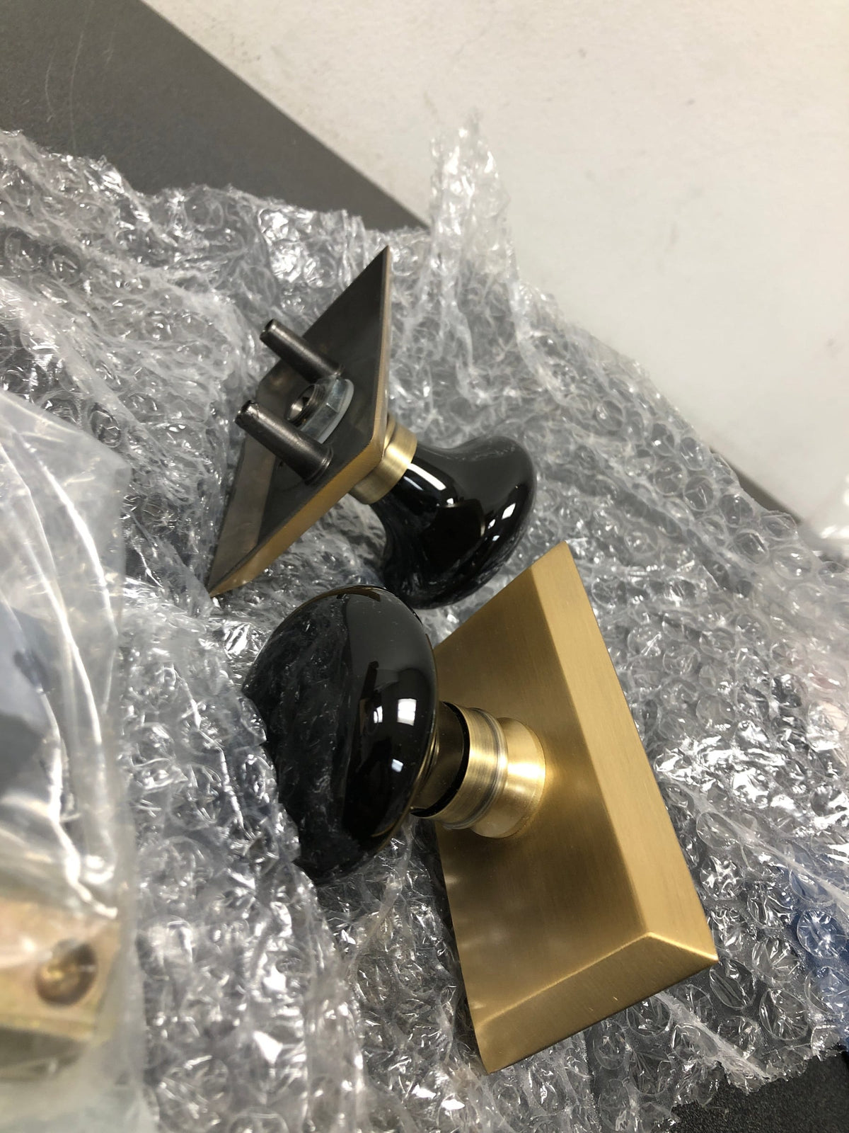 Nostalgic Warehouse 713379 Black Porcelain Solid Brass Privacy Door Knob Set with Studio Rose and 2-3/8" Backset - Antique Brass